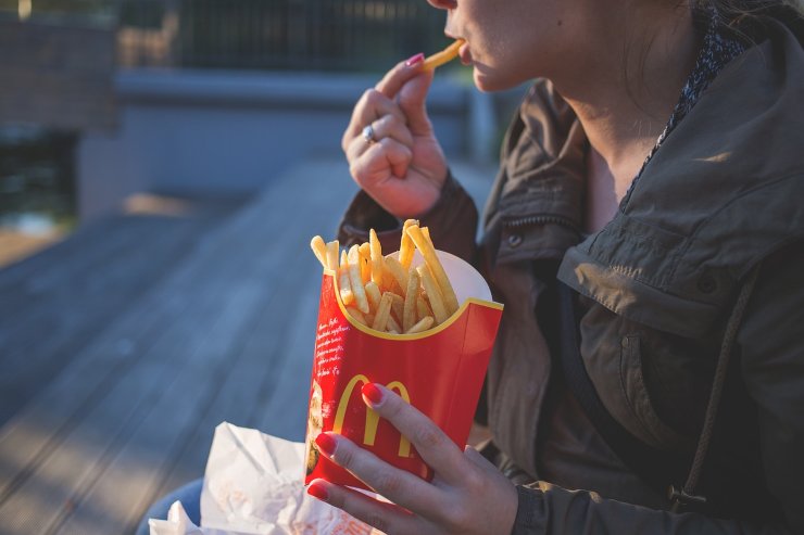 Una ragazza mentre mangia patatine (Pixabay)