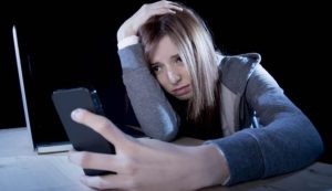 Ragazza triste con smartphone (Depositphotos foto)